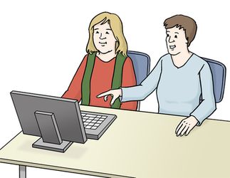Zwei Menschen sitzen vor einem Computer